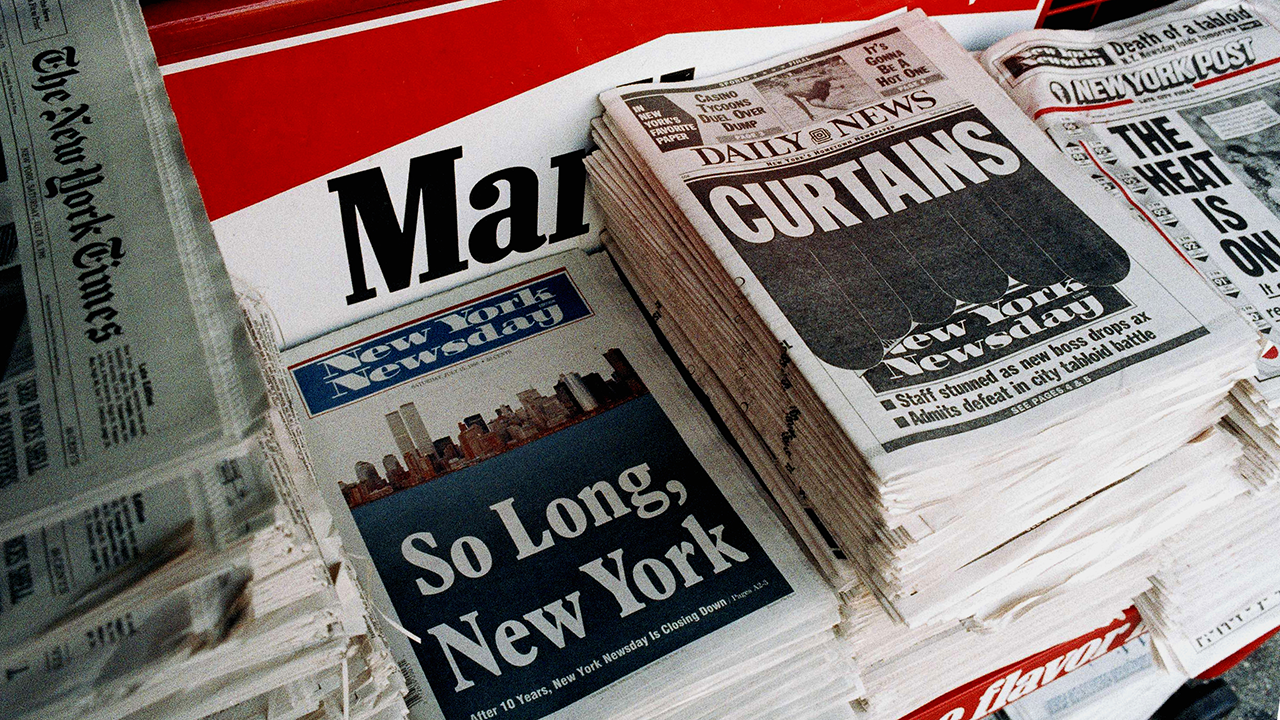 A newsstand carries the four top daily newspapers the day after it was announced that New York Newsday, second from left, will cease publication, July 15, 1995. (AP Photo/Mark Lennihan)